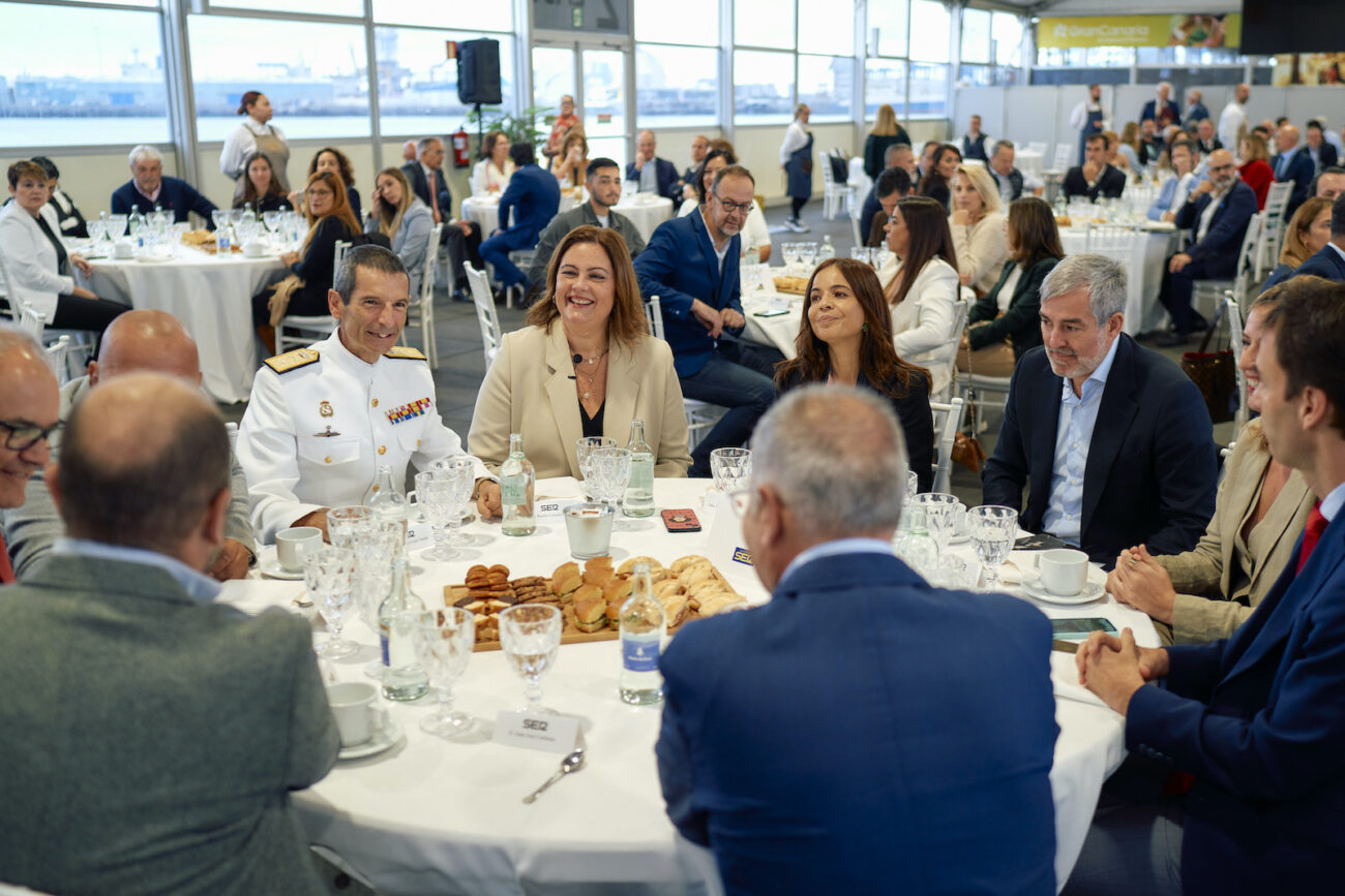 Personas sentadas en una mesa redonda con comida y bebida