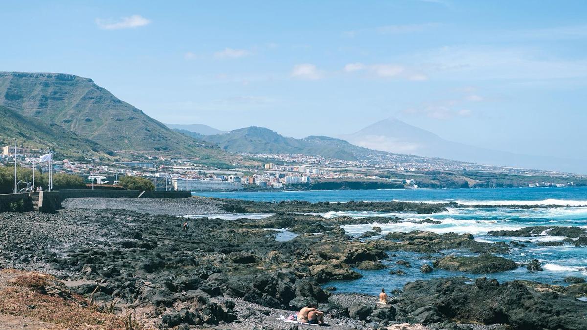 una playa en la laguna con montañas de fondo