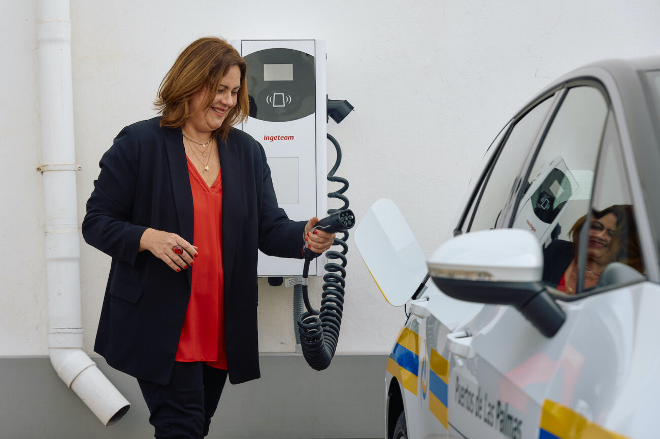 Mujer enchufando un coche eléctrico